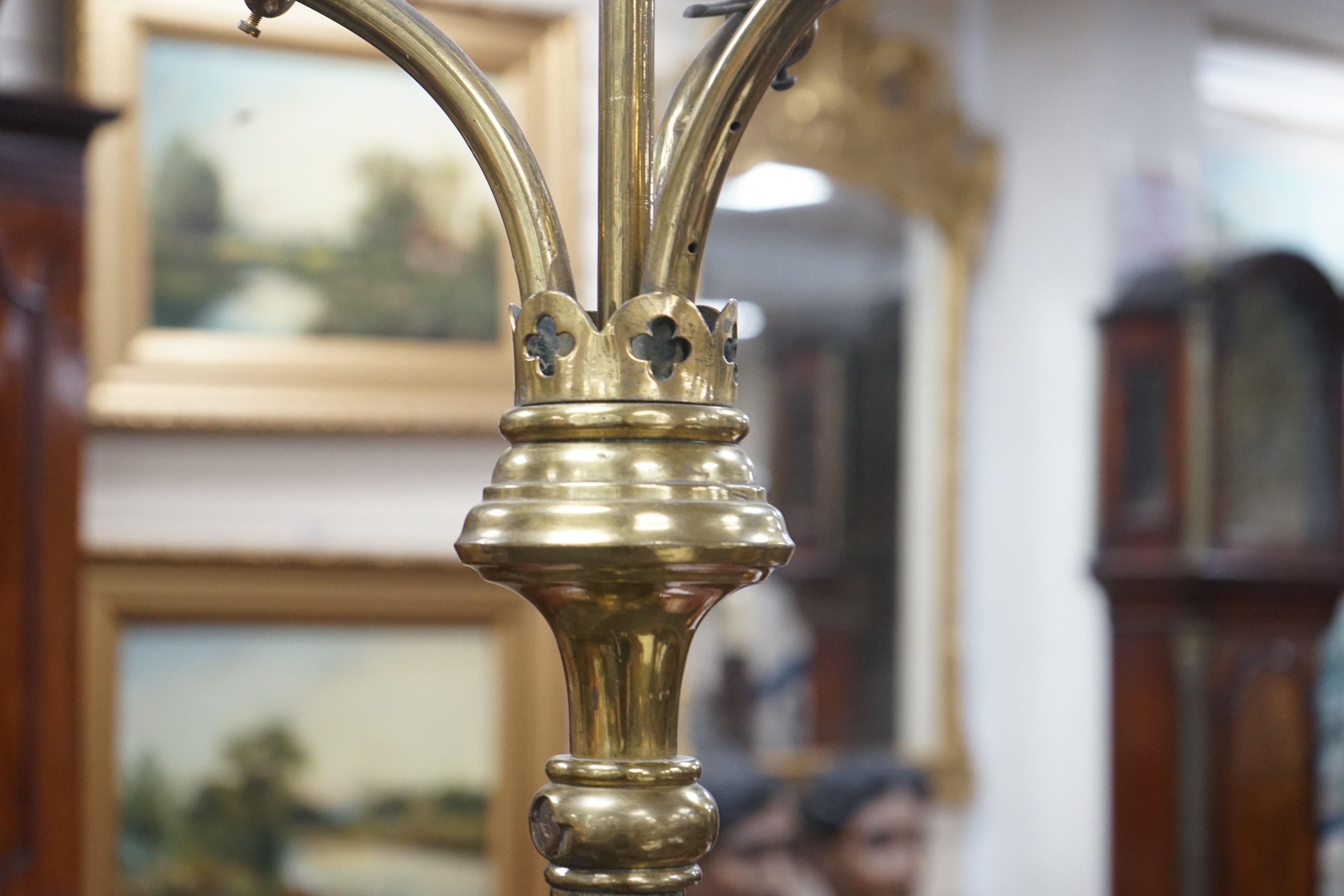 A pair of Victorian Gothic brass ecclesiastical three branch floor lamps, converted to electricity, height 195cm